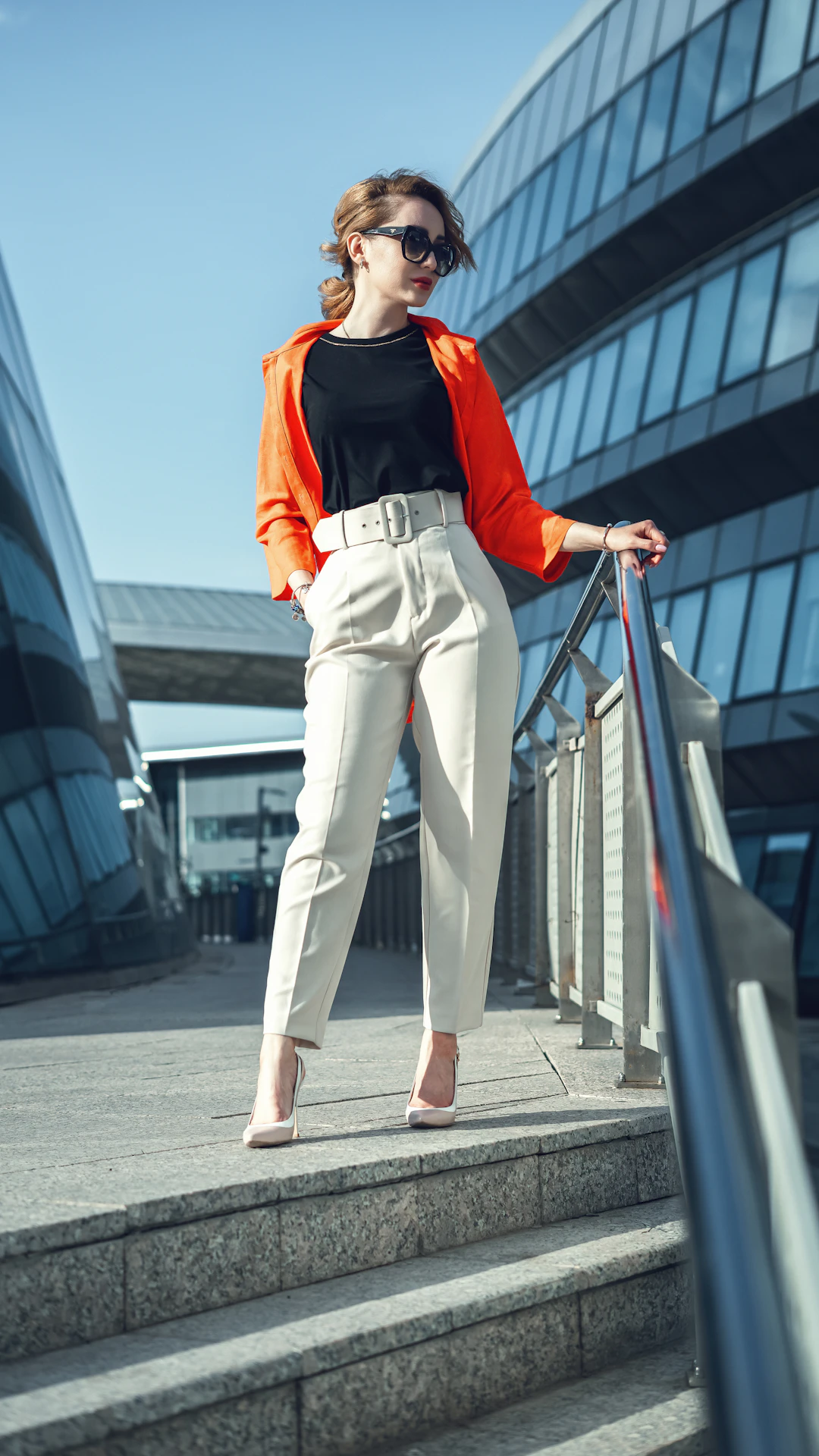 a woman in a black top and white pants