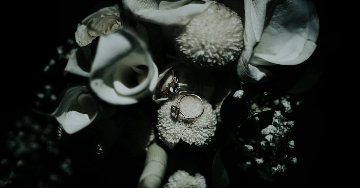 grayscale photo of flowers and ring