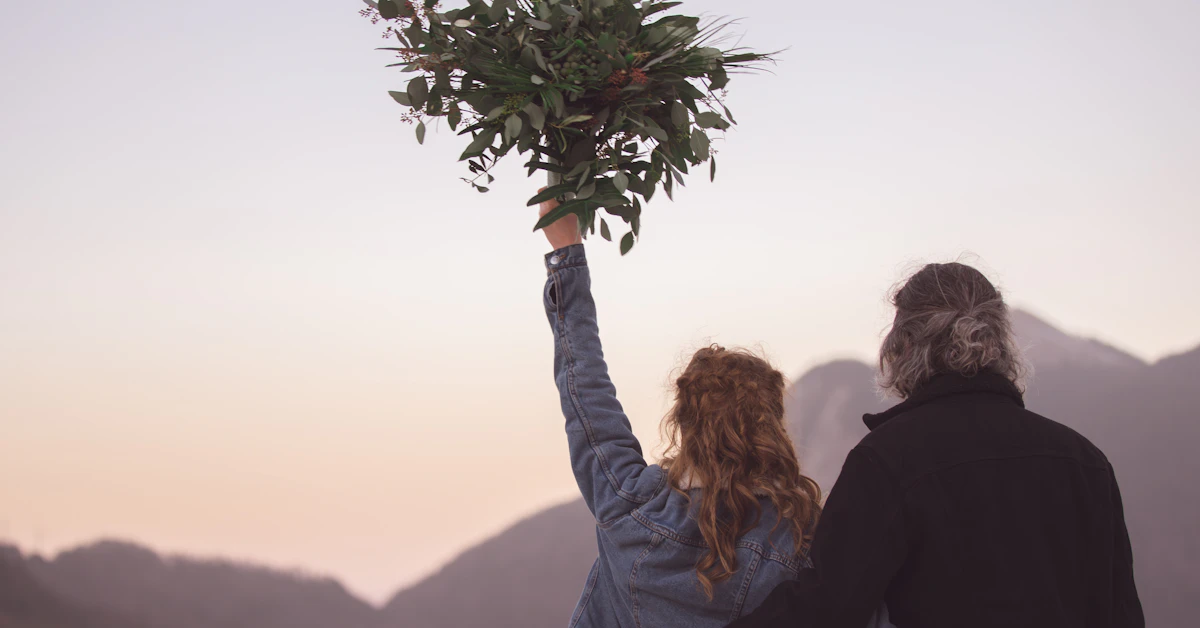 woman in black jacket holding green plant