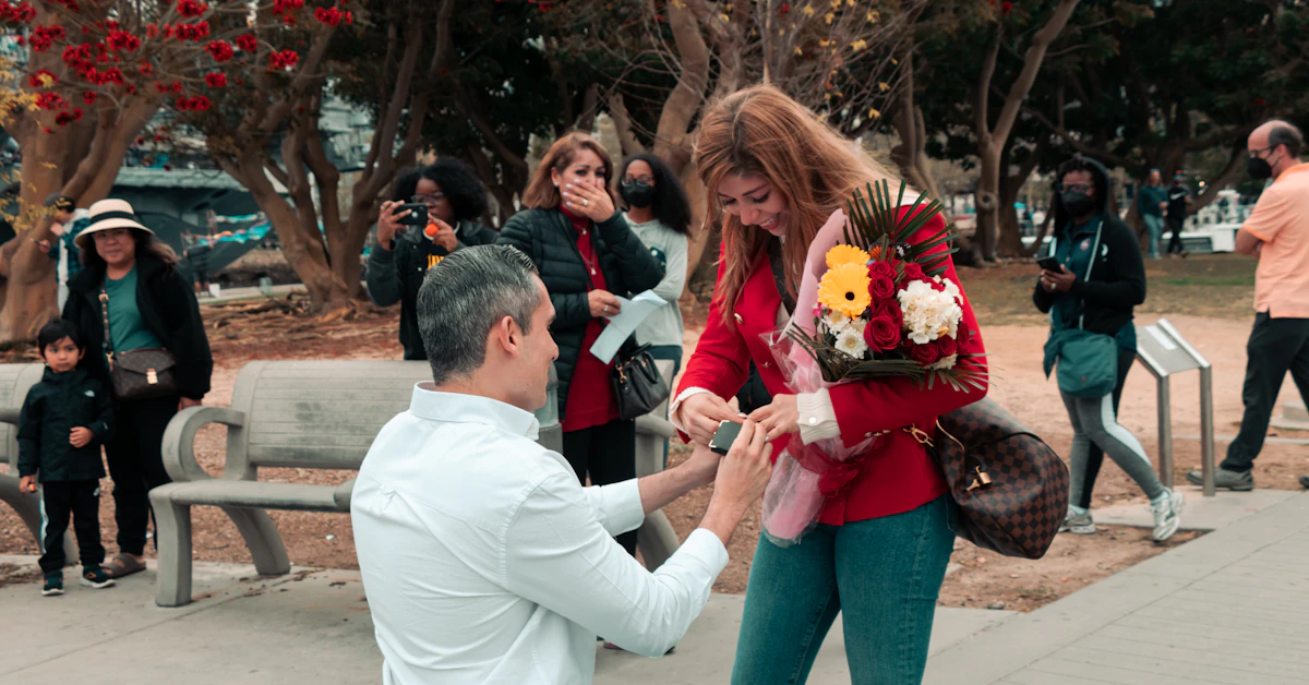 a man kneeling down next to a woman on a bench