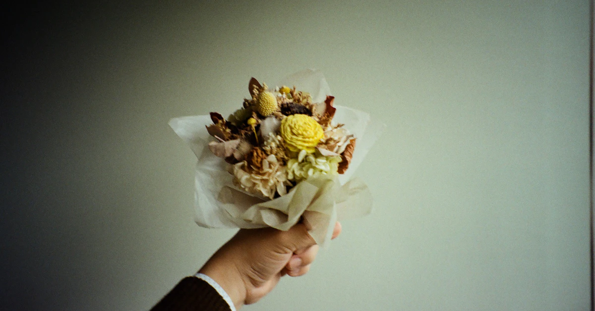 a person holding a bouquet of flowers in their hand