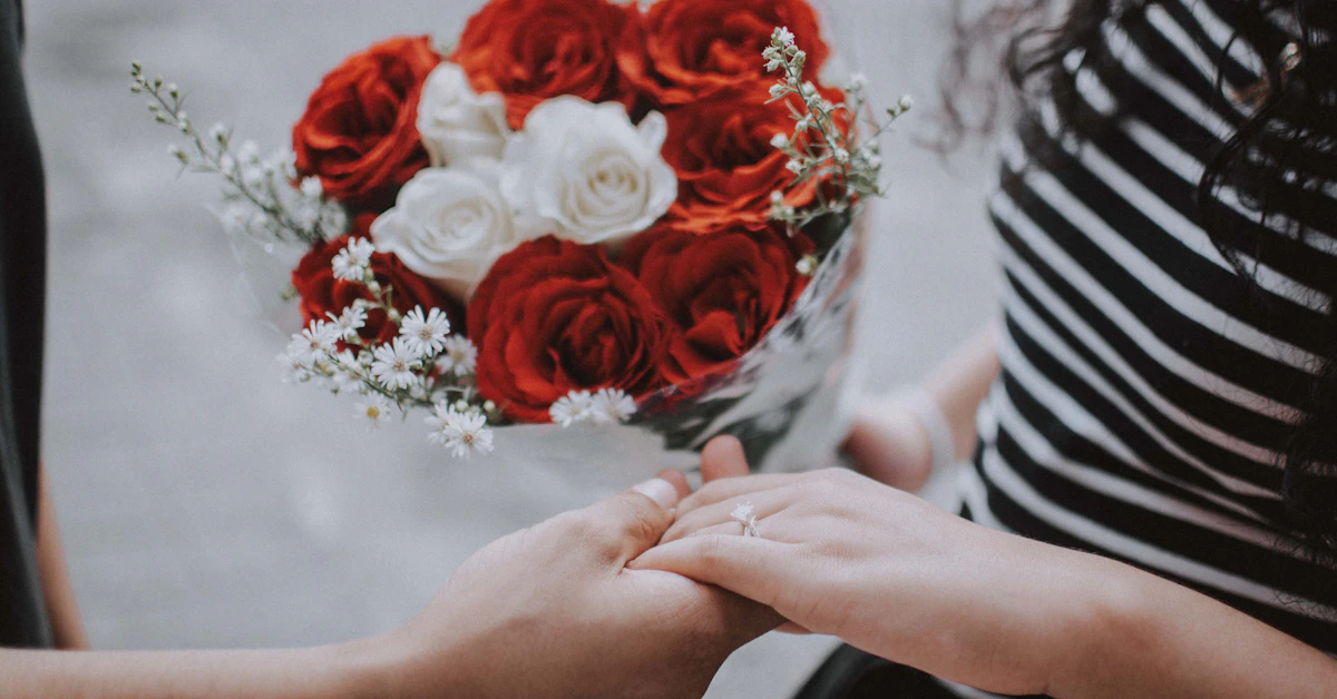person holding red roses bouquet