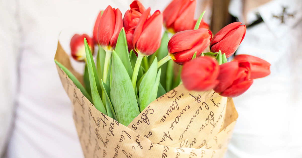 a bouquet of red tulips in a paper bag