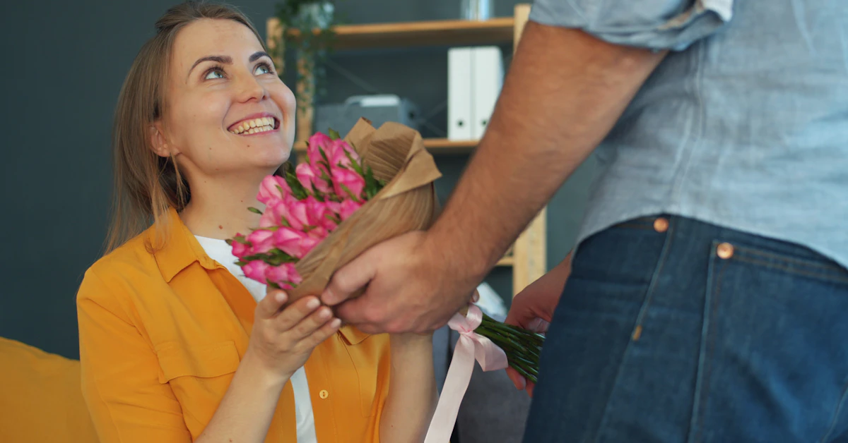 Man gives woman a bouquet of pink roses