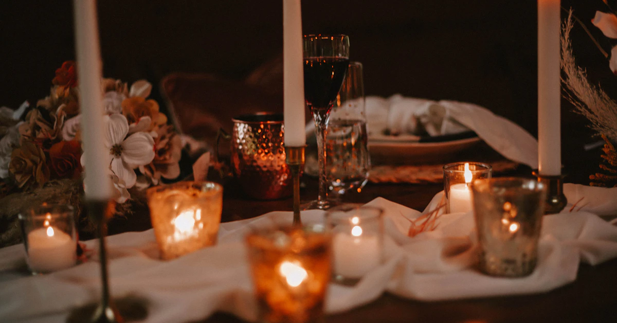 a table topped with candles and plates of food